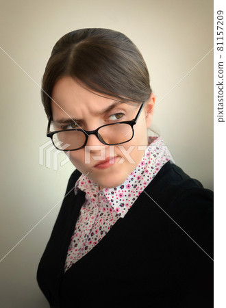 Young girl with a sour face suspiciously looking away 81157209