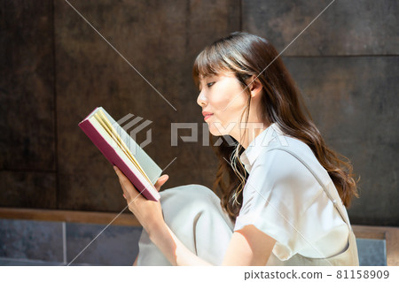 A woman reading in a sunny room A woman reading in a sunny room 81158909