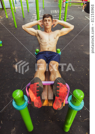 One young handsome caucasian man in sportswear training, exercising on sports ground outdoors on bright summer day. One young handsome caucasian man in sportswear training, exercising on sports ground outdoors on bright summer day. 81158968
