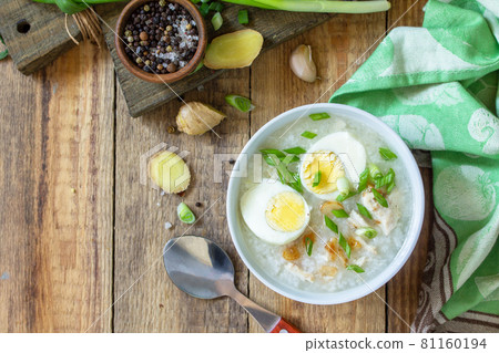 Hot soup chicken with ginger rice and garlic in a bowl on a rustic table. Top view flat lay. Copy space. 81160194