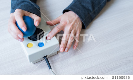Woman with cerebral palsy works on a specialized computer mouse. Woman with cerebral palsy works on a specialized computer mouse. 81160926