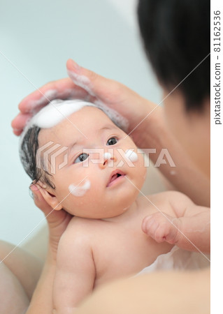 Daddy bathing a baby 81162536