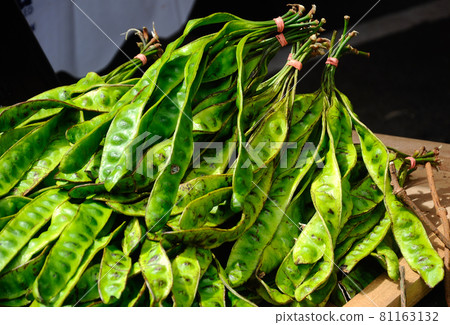 Ripe petai fruit or parkia speciosa (bitter bean, twisted cluster bean, stinker or stink bean) display for sale on the wooden table. Ripe petai fruit or parkia speciosa (bitter bean, twisted cluster bean, stinker or stink bean) display for sale on the wooden table. 81163132