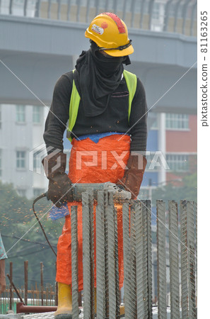 SELANGOR, MALAYSIA -AUGUST 29, 2016: Construction workers cutting reinforcement bar using mobile grinder at the construction site in Selangor, Malaysia.  81163265