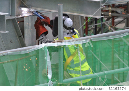 SELANGOR, MALAYSIA -SEPTEMBER 23, 2016: Welder wearing protective mask while welding metal at the construction site. SELANGOR, MALAYSIA -SEPTEMBER 23, 2016: Welder wearing protective mask while welding metal at the construction site. 81163274