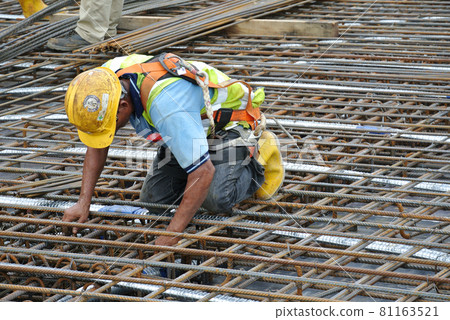 MALACCA, MALAYSIA -SEPTEMBER 24, 2016: Construction workers fabricating floor slab reinforcement bar at the construction site in Malacca, Malaysia. MALACCA, MALAYSIA -SEPTEMBER 24, 2016: Construction workers fabricating floor slab reinforcement bar at the construction site in Malacca, Malaysia. 81163521