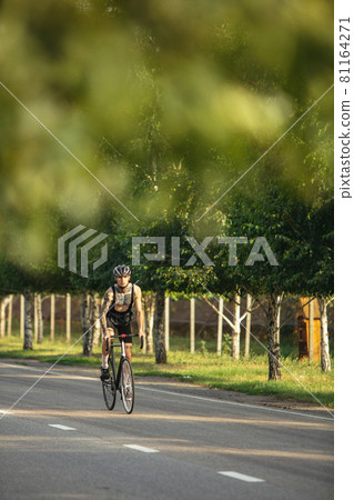 Young male cyclist riding a road bike in summer day. Action, motion concept Young male cyclist riding a road bike in summer day. Action, motion concept 81164271