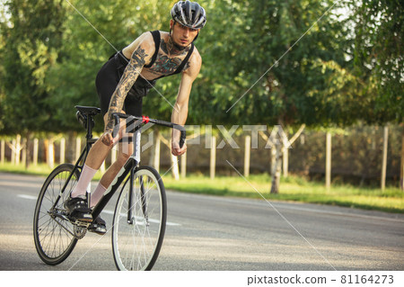 Young male cyclist riding a road bike in summer day. Action, motion concept Young male cyclist riding a road bike in summer day. Action, motion concept 81164273