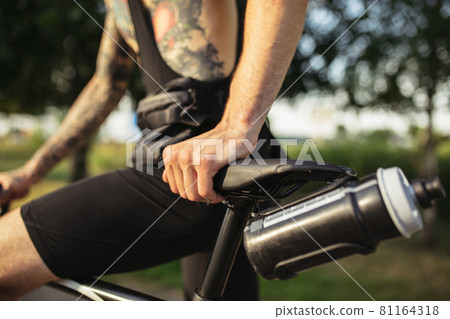 Young male cyclist with road bike in summer day. Action, motion concept. Cropped image 81164318