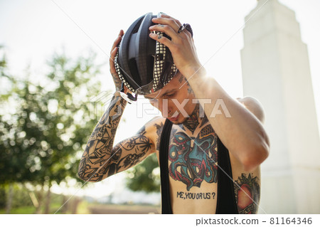 Young male cyclist wearing protective helmet before riding a bike. Active lifestyle concept Young male cyclist wearing protective helmet before riding a bike. Active lifestyle concept 81164346