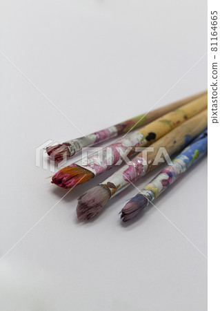 dirty art paint brusches of different sizes and colors on white background, copy space 81164665