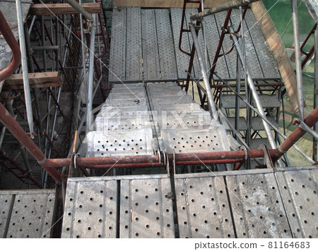 MALACCA, MALAYSIA -SEPTEMBER 23, 2016: Temporary access and staircase supported by reinforced scaffolding at the construction site. Used by construction workers. MALACCA, MALAYSIA -SEPTEMBER 23, 2016: Temporary access and staircase supported by reinforced scaffolding at the construction site. Used by construction workers. 81164683