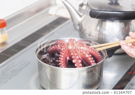 Hands of a man boiling an octopus 81164707