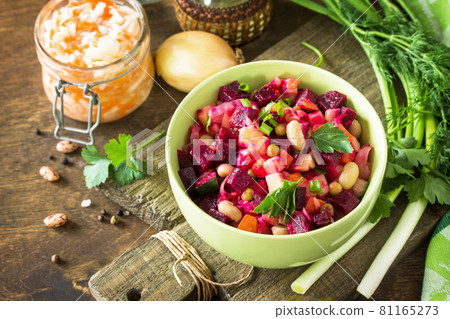 Beetroot salad vinaigrette with sauerkraut, pickled cucumber and vegetables on a wooden rustic table. 81165273