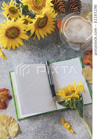 Good Morning. To do list concept. A bouquet of large sunflowers, coffee cup and empty notebook on a stone table. Good Morning. To do list concept. A bouquet of large sunflowers, coffee cup and empty notebook on a stone table. 81165296
