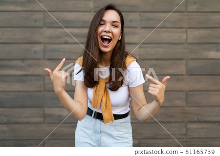 Portrait of young happy positive beautiful brunette woman with sincere emotions wearing stylish 81165739