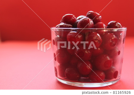 cherry in a glass on a pink red background with a place to text the view from the side close-up of the copyspace 81165926