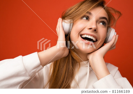 Portrait of charming emotional positive young blonde woman wearing white hoodie isolated over Portrait of charming emotional positive young blonde woman wearing white hoodie isolated over 81166189