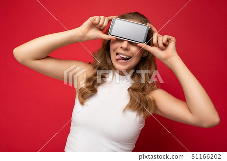 Portrait photo of funny young blonde woman wearing white t-shirt isolated on red background with 81166202