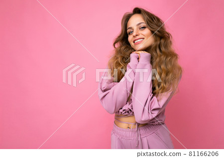 Young beautiful curly blonde woman with sexy expression, cheerful and happy face wearing trendy pink 81166206