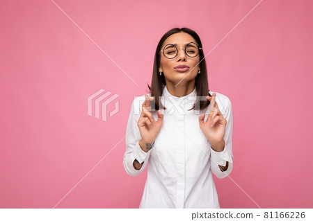 Portrait of young emotional pretty brunette lady with short haircut wearing casual white shirt and 81166226