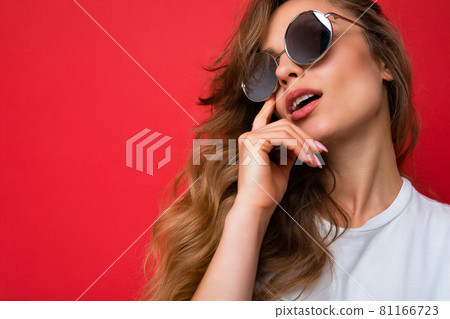 Closeup shot of beautiful sexy thoughful young dark blonde curly woman isolated over red background Closeup shot of beautiful sexy thoughful young dark blonde curly woman isolated over red background 81166723