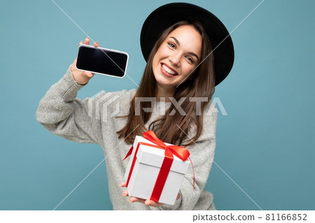 Shot of pretty smiling positive young brunet female person isolated over blue background wall 81166852