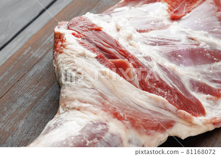 Raw beef leg on brown wooden board 81168072