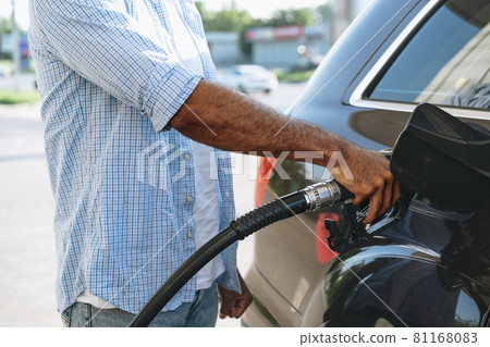 Man filling gasoline fuel in car at gas station 81168083