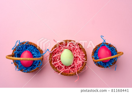 Painted Easter eggs in decorative nest on pink background Painted Easter eggs in decorative nest on pink background 81168441