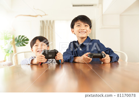 Two boys playing on a home video game console 81170078