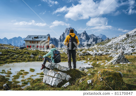 Couple in Dolomites. Rifugio Lavaredo with Cadini di Misurina mountain group in background. Italy Couple in Dolomites. Rifugio Lavaredo with Cadini di Misurina mountain group in background. Italy 81170847