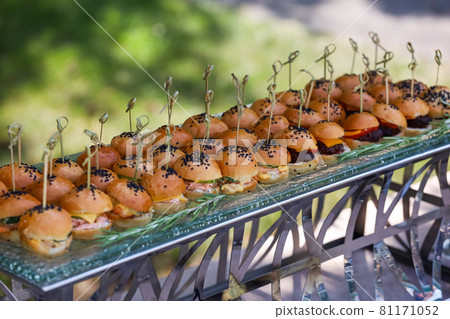 Mini burgers with black sesame seeds at a buffet table Mini burgers with black sesame seeds at a buffet table 81171052