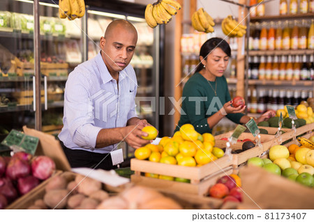 Latin american man choosing ripe mandarines in food store Latin american man choosing ripe mandarines in food store 81173407