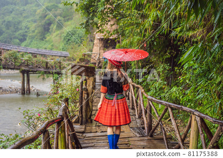 A female tourist dressed in the traditional dress of the inhabitants of the Vietnamese mountains, the Hmong. Woman in Sapa in the fog, Northwest Vietnam. Vietnam travel concept. UNESCO heritage A female tourist dressed in the traditional dress of the inhabitants of the Vietnamese mountains, the Hmong. Woman in Sapa in the fog, Northwest Vietnam. Vietnam travel concept. UNESCO heritage 81175388