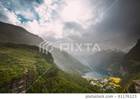 Geirangerfjord, Norway - Geiranger In Geirangerfjorden In Rainy Summer Day. Famous Norwegian Landmark And Popular Destination Geirangerfjord, Norway - Geiranger In Geirangerfjorden In Rainy Summer Day. Famous Norwegian Landmark And Popular Destination 81176123