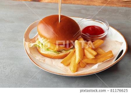 Fresh burger and potato wedges on gray wooden background 81176625