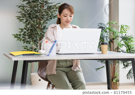 Young woman doing desk work in front of a laptop 81178455