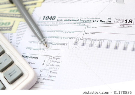 The pen, notebook, calculator, and dollar bills is lies on the tax form 1040 U.S. Individual Income Tax Return. The time to pay taxes The pen, notebook, calculator, and dollar bills is lies on the tax form 1040 U.S. Individual Income Tax Return. The time to pay taxes 81178886