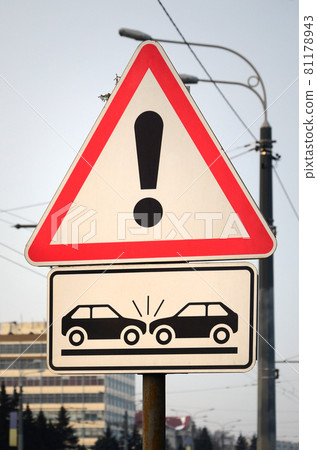 High risk of collision. A road sign with an exclamation point and two cars that crashed into each other High risk of collision. A road sign with an exclamation point and two cars that crashed into each other 81178943
