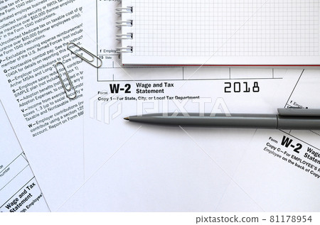 The pen and notebook on the tax form W-2 Wage and Tax Statement. The time to pay taxes The pen and notebook on the tax form W-2 Wage and Tax Statement. The time to pay taxes 81178954