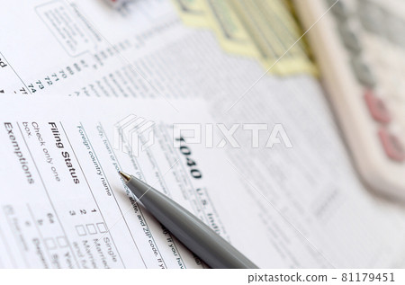 The pen, notebook, calculator, and dollar bills is lies on the tax form 1040 U.S. Individual Income Tax Return. The time to pay taxes The pen, notebook, calculator, and dollar bills is lies on the tax form 1040 U.S. Individual Income Tax Return. The time to pay taxes 81179451