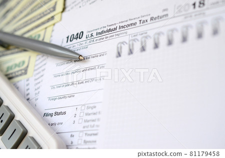 The pen, notebook, calculator, and dollar bills is lies on the tax form 1040 U.S. Individual Income Tax Return. The time to pay taxes 81179458