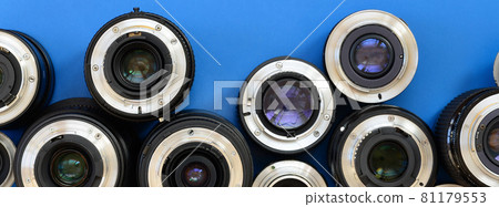 Several photographic lenses lie on a bright blue background. Space for text 81179553