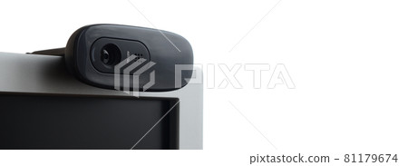 A modern web camera is installed on the body of a flat screen monitor. Device for video communication and recording of high quality video 81179674
