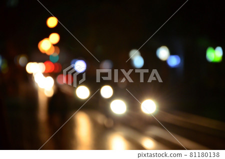 Blurred night scene of traffic on the roadway. Defocused image of cars traveling with luminous headlights. Bokeh Art Blurred night scene of traffic on the roadway. Defocused image of cars traveling with luminous headlights. Bokeh Art 81180138