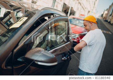 Young disabled man open vihicle car door with artificial prosthetic hand. Young disabled man open vihicle car door with artificial prosthetic hand. 81180340