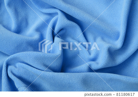 The blanket of furry blue fleece fabric. A background of light blue soft plush fleece material with a lot of relief folds The blanket of furry blue fleece fabric. A background of light blue soft plush fleece material with a lot of relief folds 81180617
