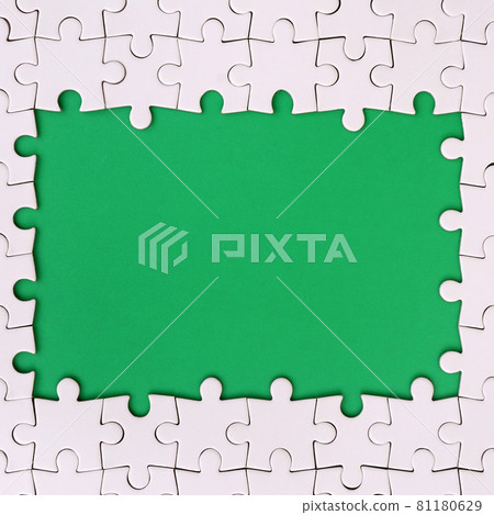Framing in the form of a rectangle, made of a white jigsaw puzzle around the green space 81180629
