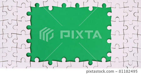 Framing in the form of a rectangle, made of a white jigsaw puzzle around the green space Framing in the form of a rectangle, made of a white jigsaw puzzle around the green space 81182495